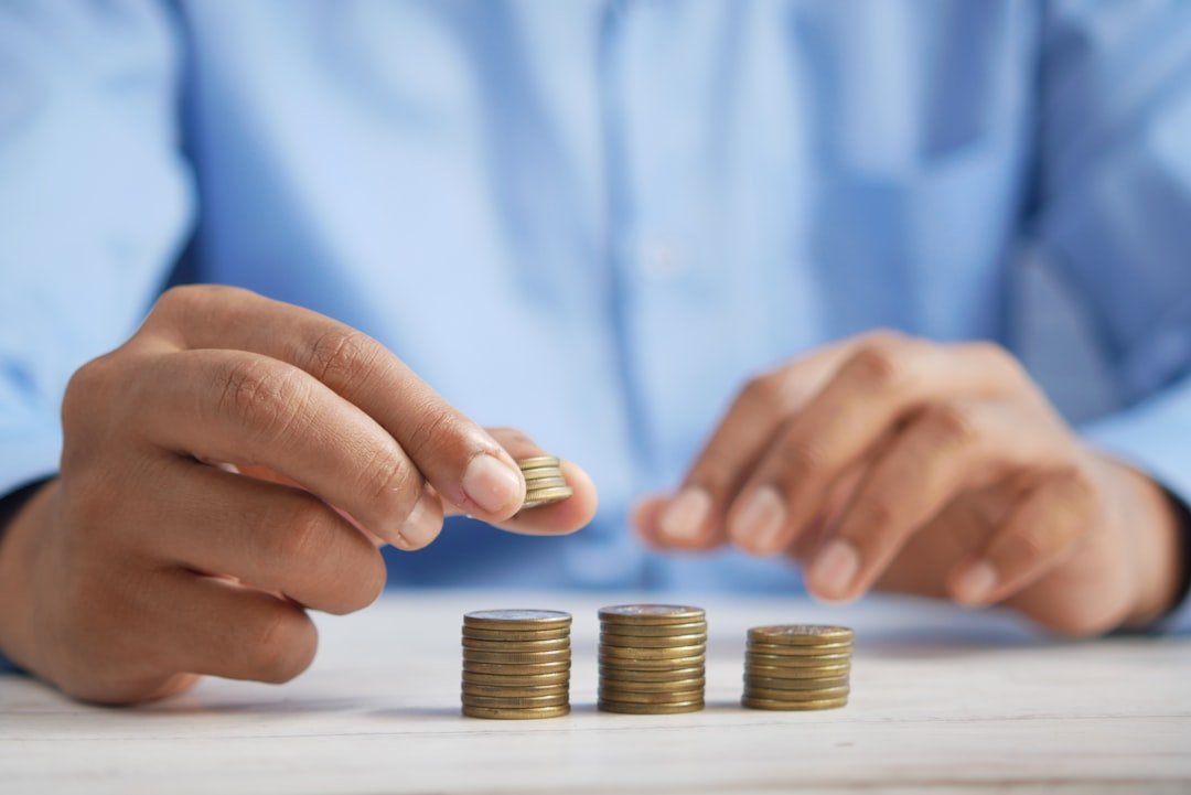 about-04 a-person-stacking-coins-on-top-of-a-table-jpqyfk7gb4w